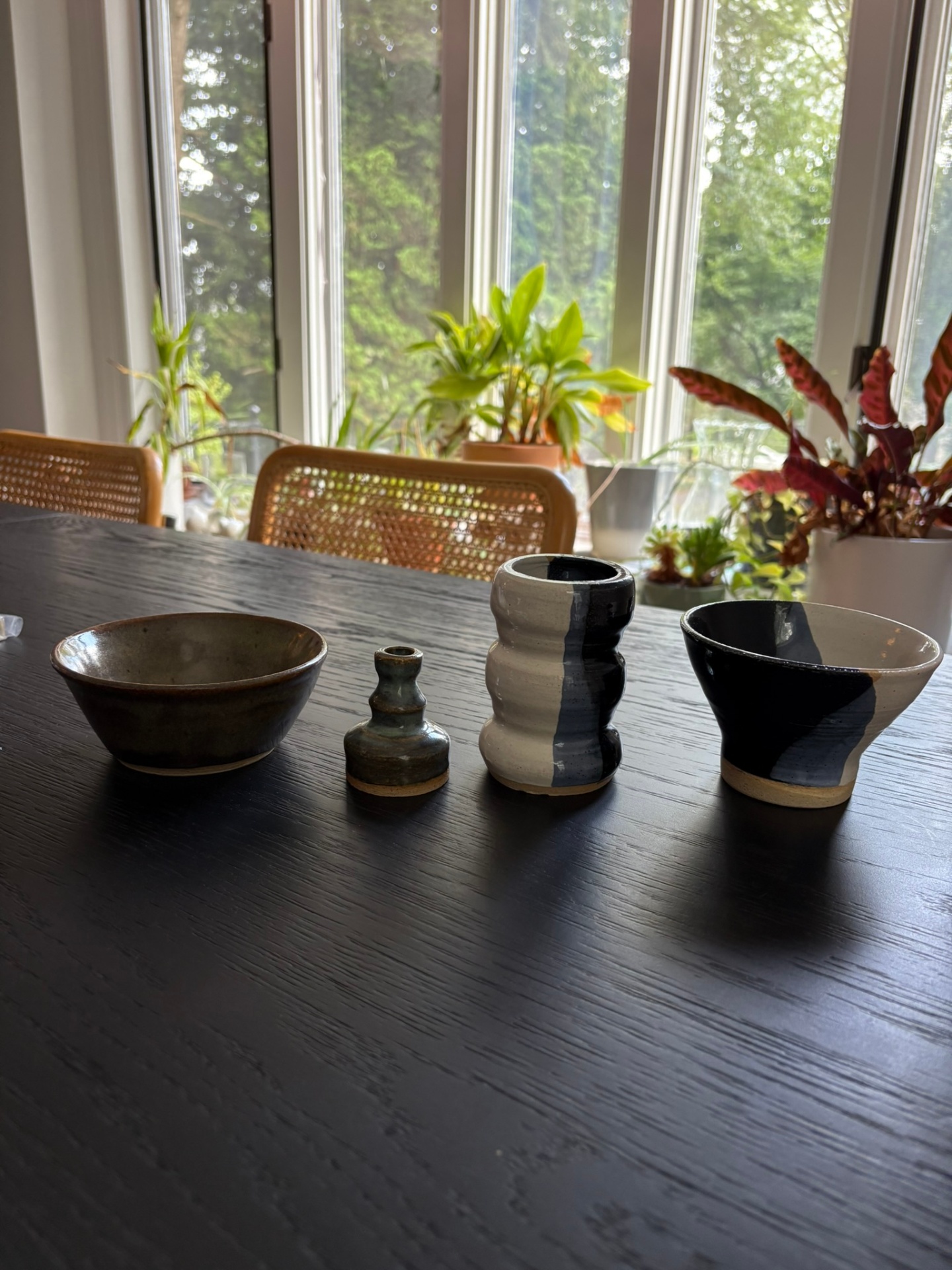 Collection of handcrafted pottery pieces including bowls, vase, and decorative items